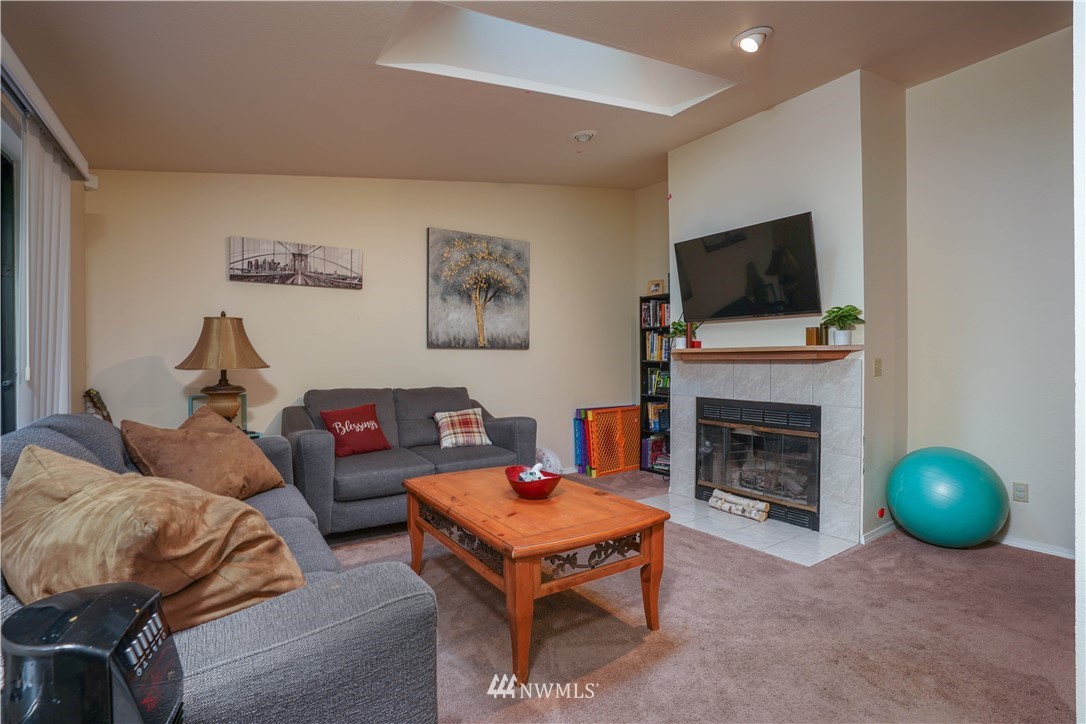 726 Roe Street Steilacoom, WA 98388 - Photo 11 of 29 a living room with furniture a flat screen tv and a fireplace