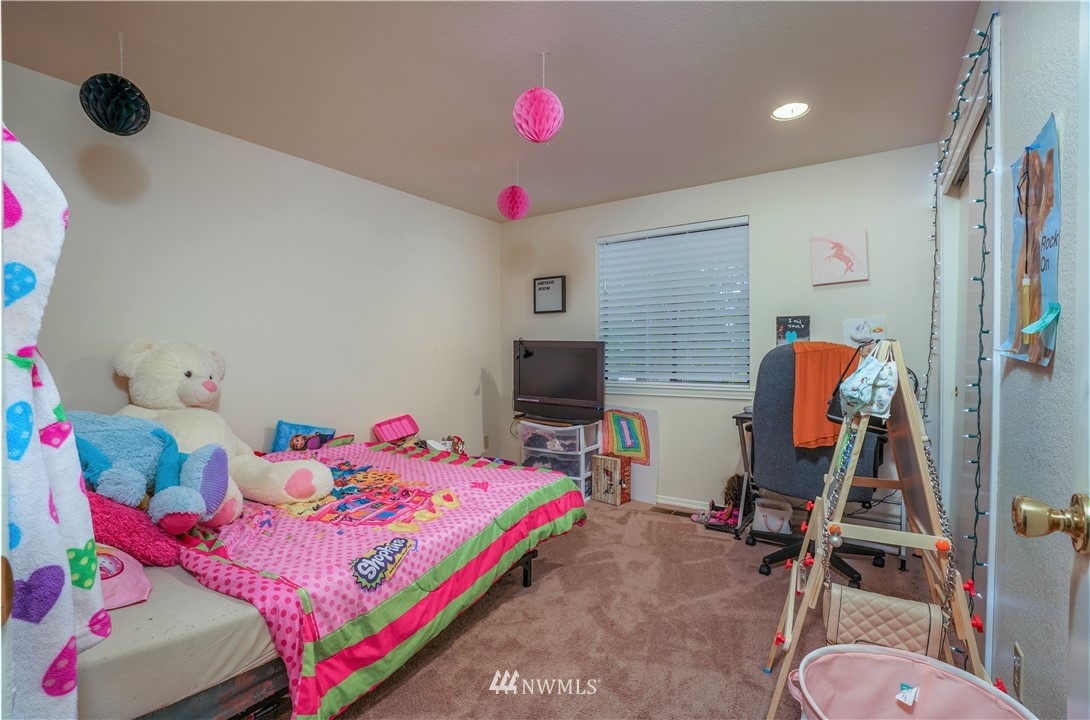 726 Roe Street Steilacoom, WA 98388 - Photo 16 of 29 a bedroom with a bed and a chandelier