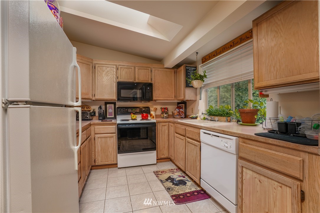 726 Roe Street Steilacoom, WA 98388 - Photo 6 of 29 a kitchen with stainless steel appliances granite countertop a refrigerator sink and stove