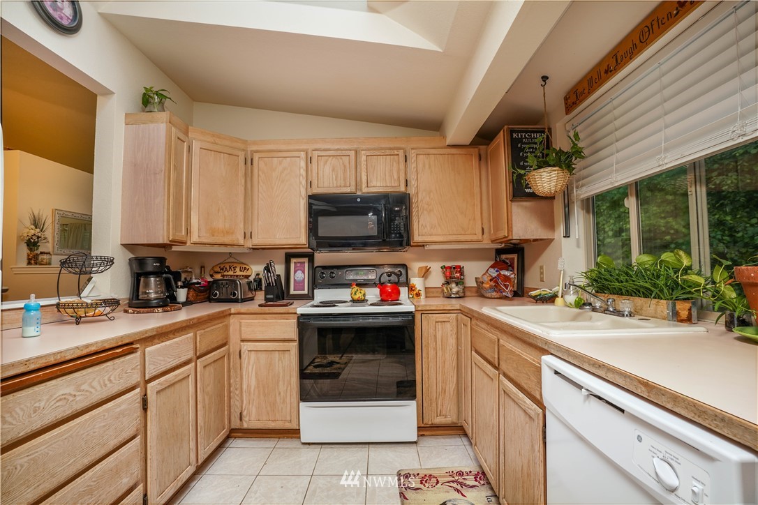 726 Roe Street Steilacoom, WA 98388 - Photo 7 of 29 a kitchen with a sink a stove and cabinets