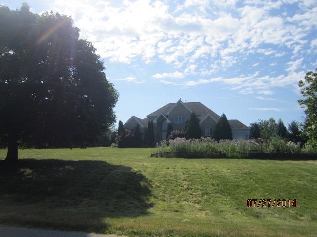 11545 Prestwick Road Belvidere, IL 61008 - Photo 2 of 14 a view of a grassy field with mountains in the background