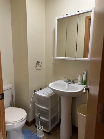 a bathroom with a sink toilet and mirror