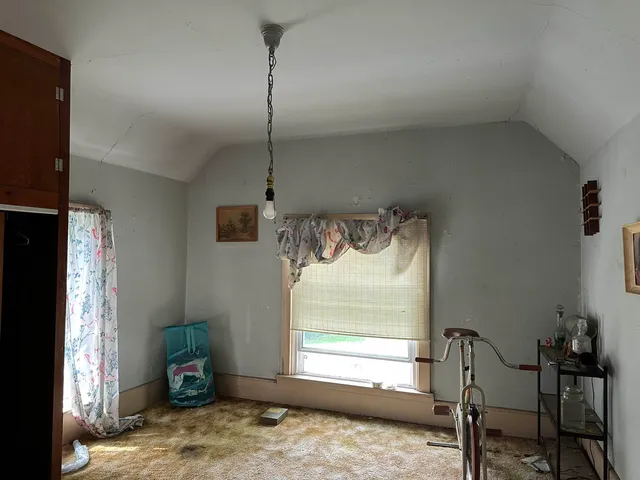 a view of a room that has a bed and a window