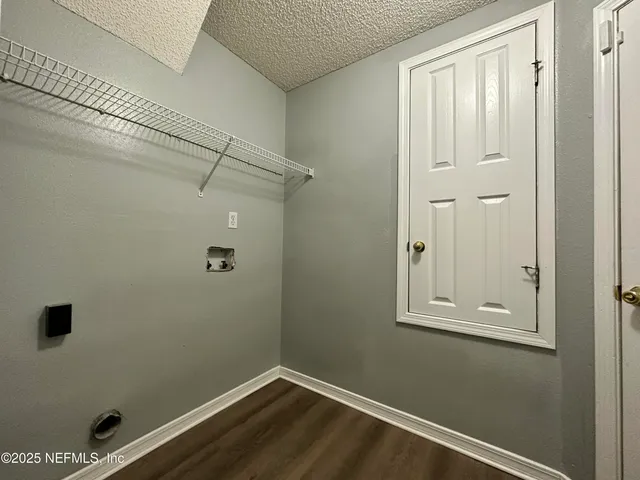 a view of a small space with wooden floor and a window