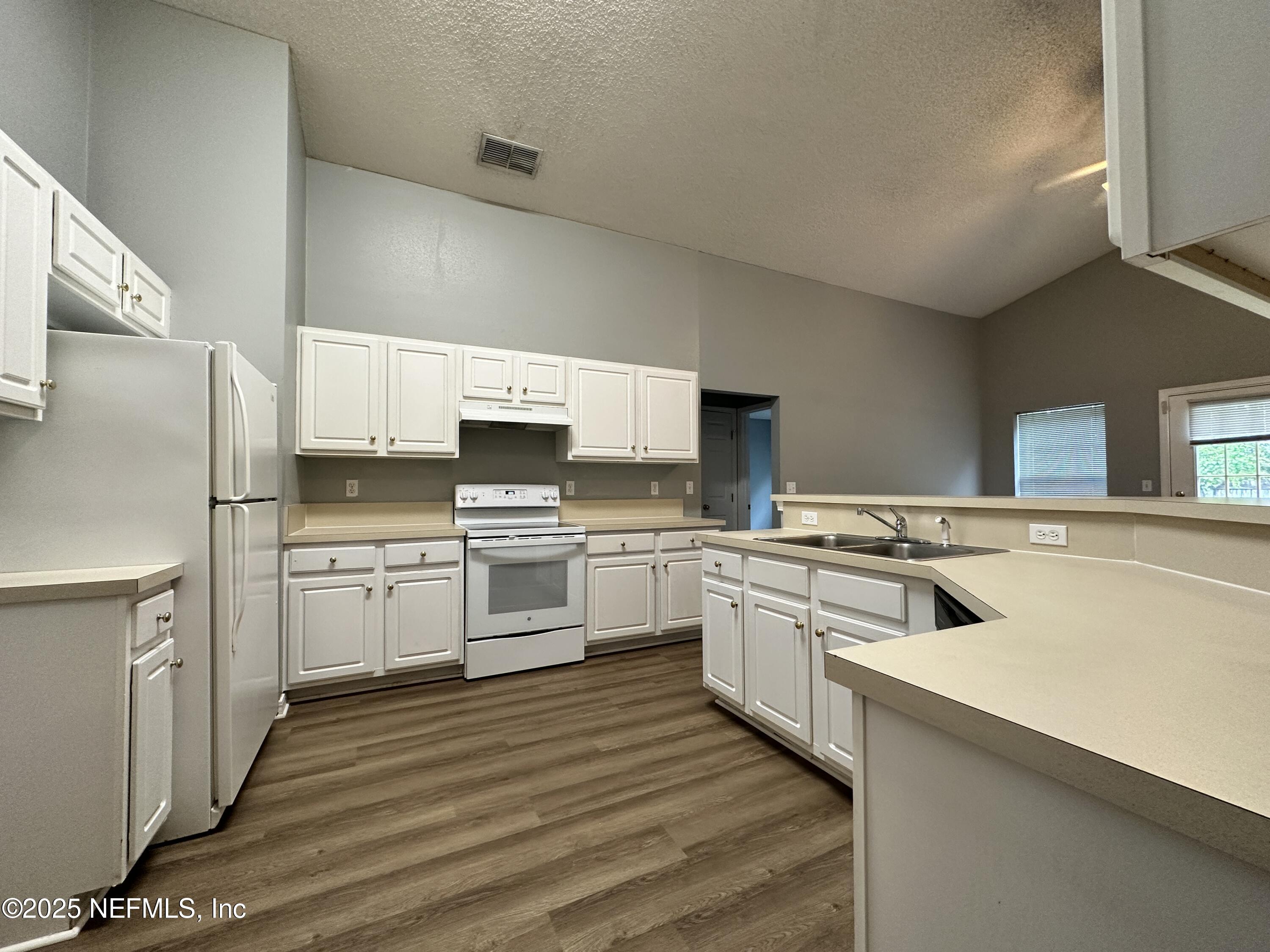 2478 Aloha Lane Middleburg, FL 32068 - Photo 4 of 16 a kitchen with white cabinets and white appliances