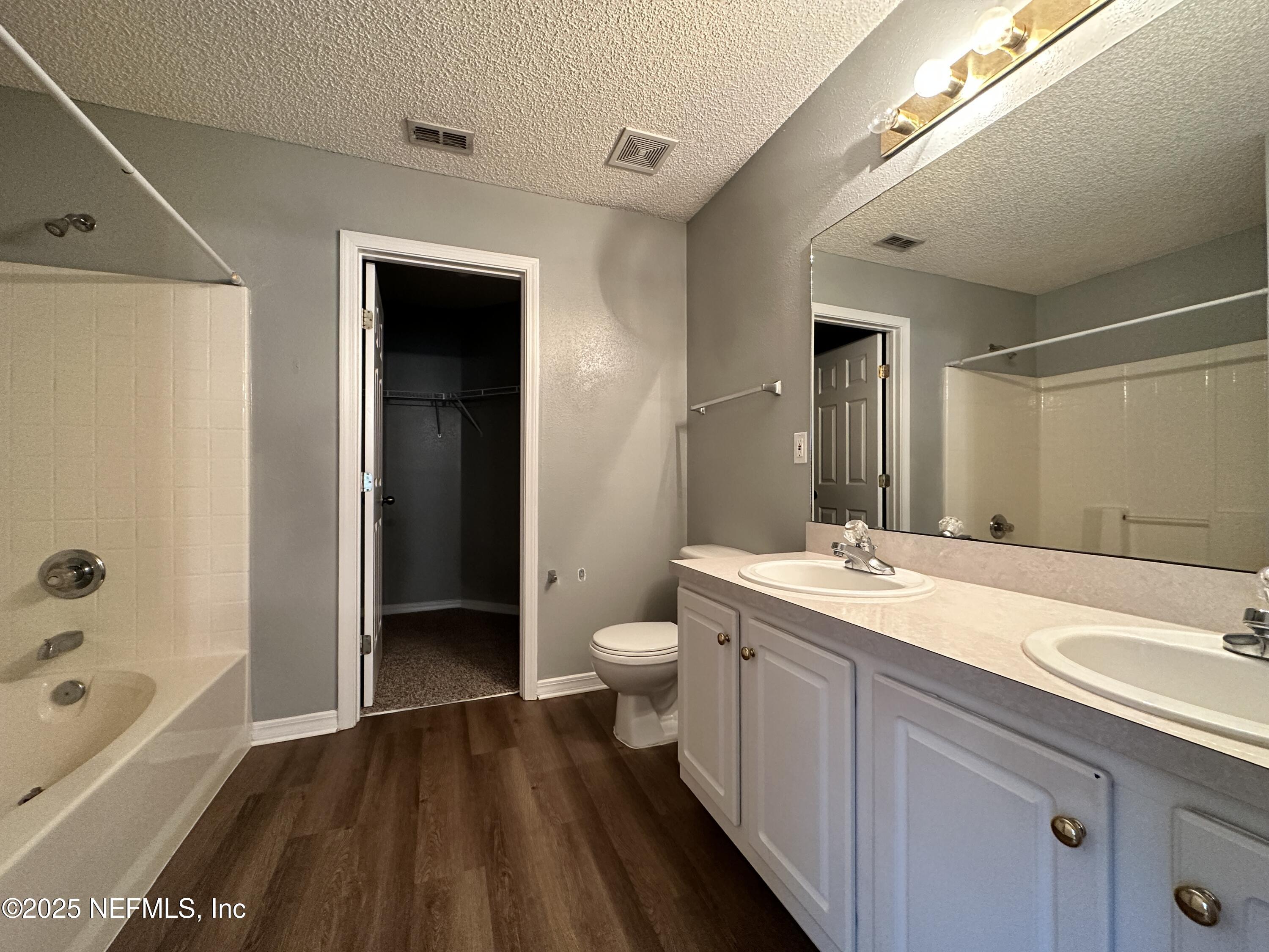 2478 Aloha Lane Middleburg, FL 32068 - Photo 8 of 16 a spacious bathroom with a granite countertop sink toilet a large mirror a bathtub and shower