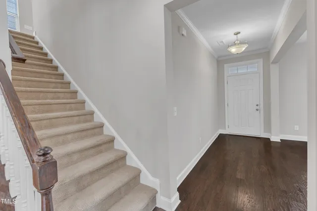 an empty room with wooden floor chandelier and windows
