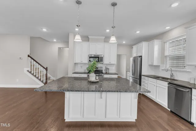 a kitchen with granite countertop white cabinets and a stove