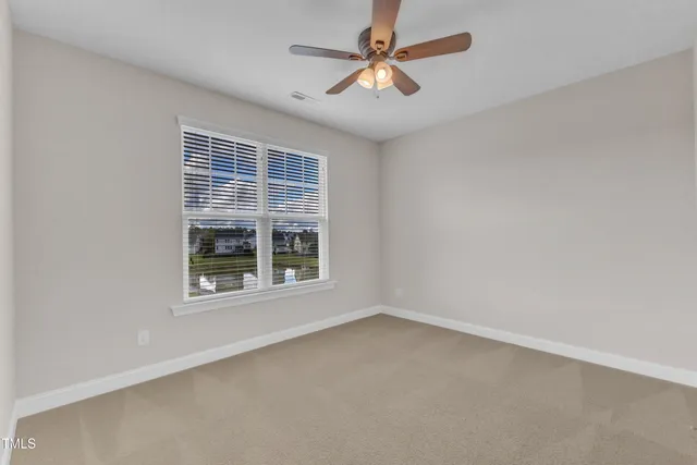 an empty room with closet and windows
