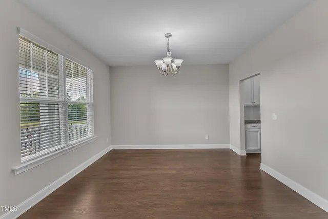 a kitchen with stainless steel appliances granite countertop a sink a stove a refrigerator cabinets and a wooden floor