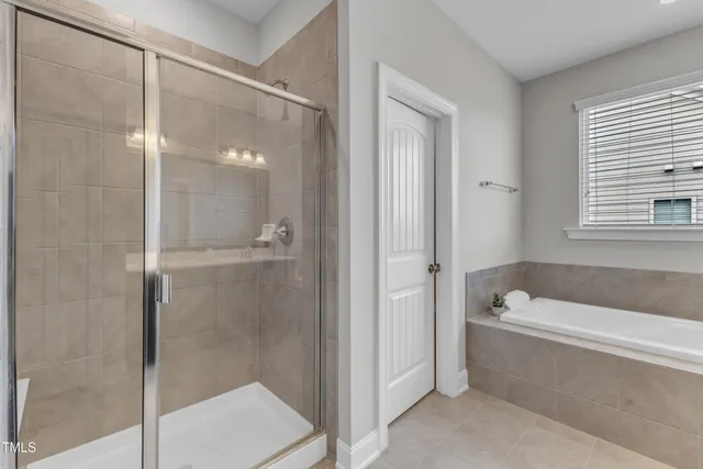 a view of a patio with table and chairs potted plants and floor to ceiling window