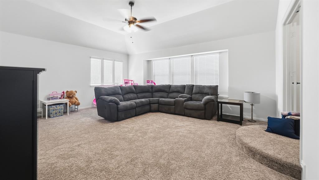 5216 Troupe Road McKinney, TX 75071 - Photo 26 of 40 Carpeted room featuring a ceiling fan with light fixture, multiple windows with blinds, a raised circular platform, and a recessed ceiling
