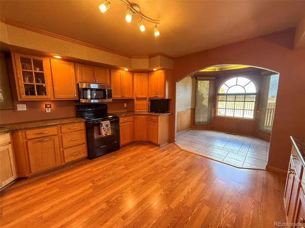 a large kitchen with stainless steel appliances granite countertop a stove a sink dishwasher and a microwave oven with cabinets