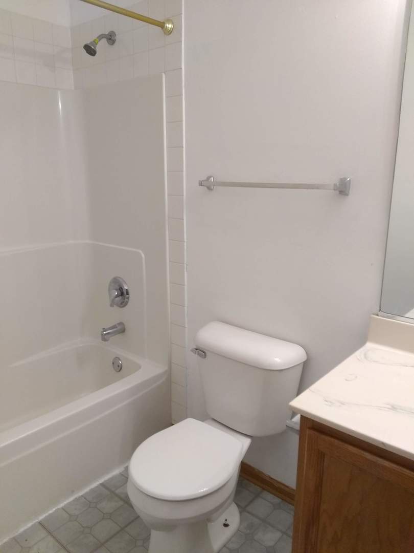 2103 Beldon Court Plainfield, IL 60586 - Photo 14 of 16 a white toilet and tub sitting next to a bathroom sink