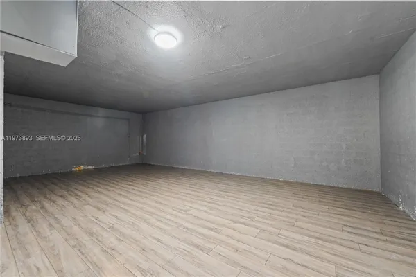a view of an empty room with window and fireplace