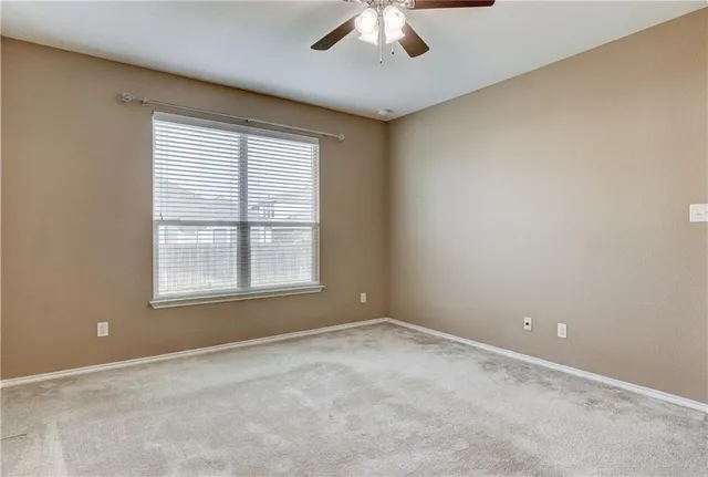 an empty room with chandelier fan