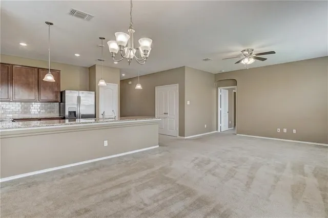 an empty room with a lamp and a chandelier fan