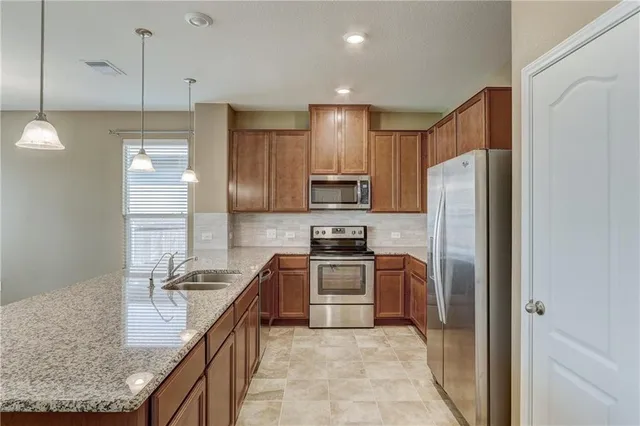 a kitchen with a refrigerator a sink and a counter top space