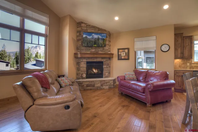 a living room with furniture a fireplace and wooden floor