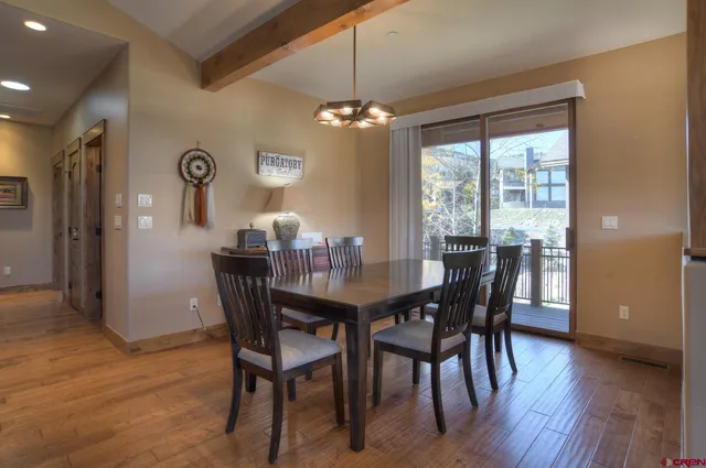 a view of a hallway with wooden floor and a bathroom