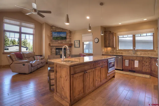 a kitchen with stainless steel appliances granite countertop wooden floors and sink