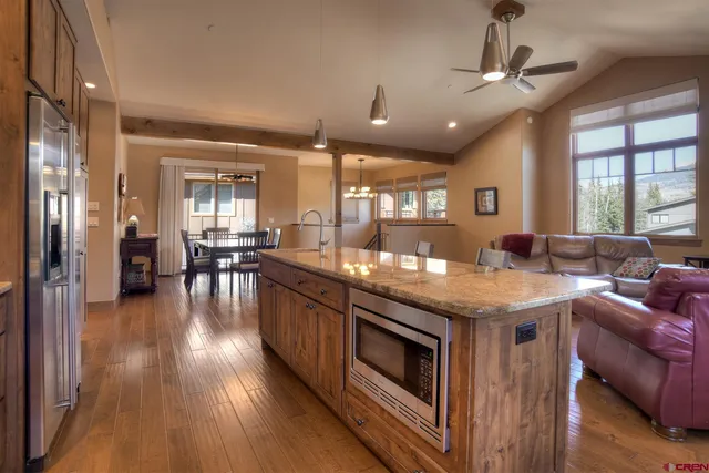 a kitchen with kitchen island granite countertop a sink stove and refrigerator