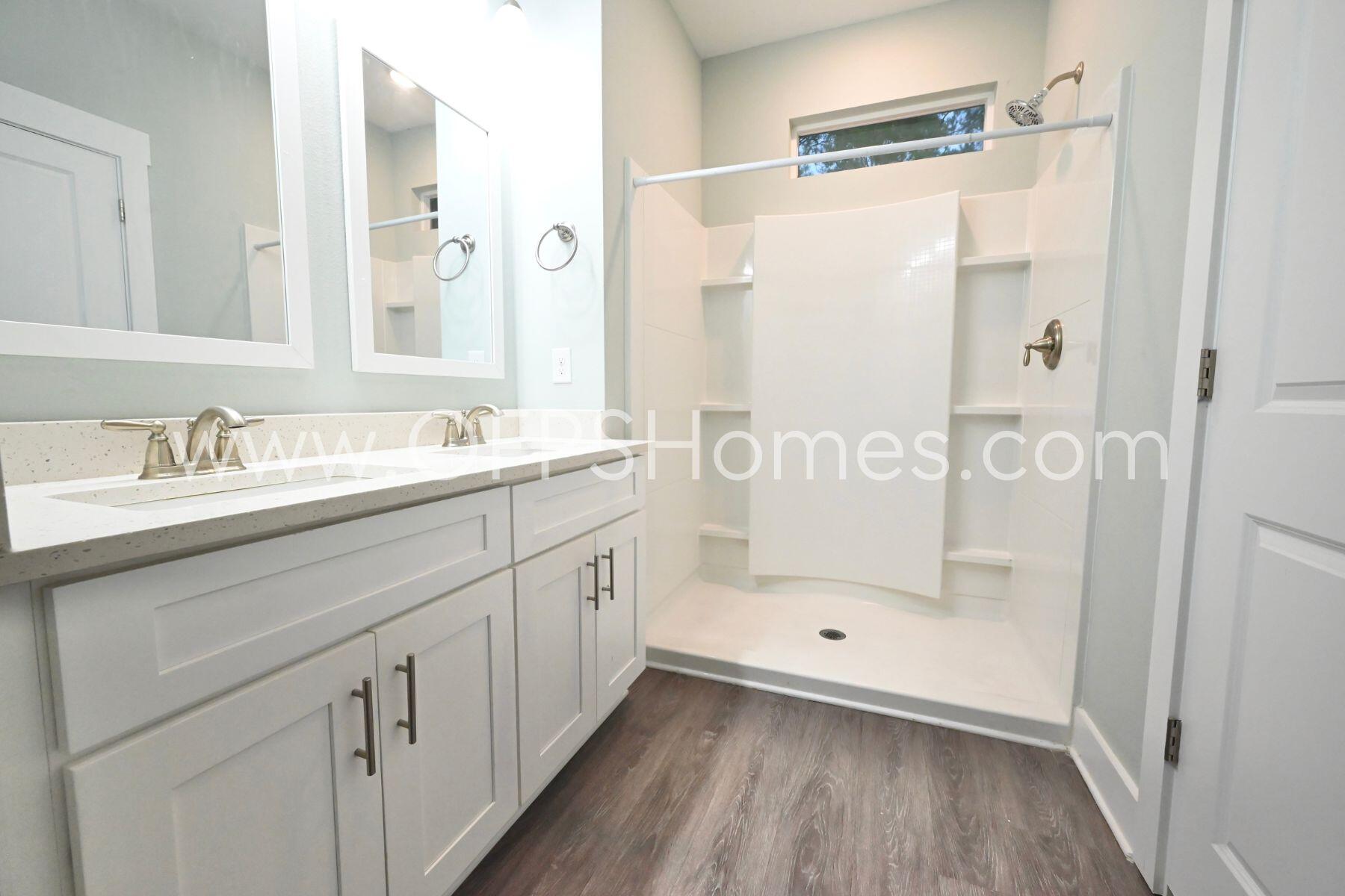 312 North Sand Palm Road Freeport, FL 32439 - Photo 15 of 26 a bathroom with a double vanity sink a toilet and shower