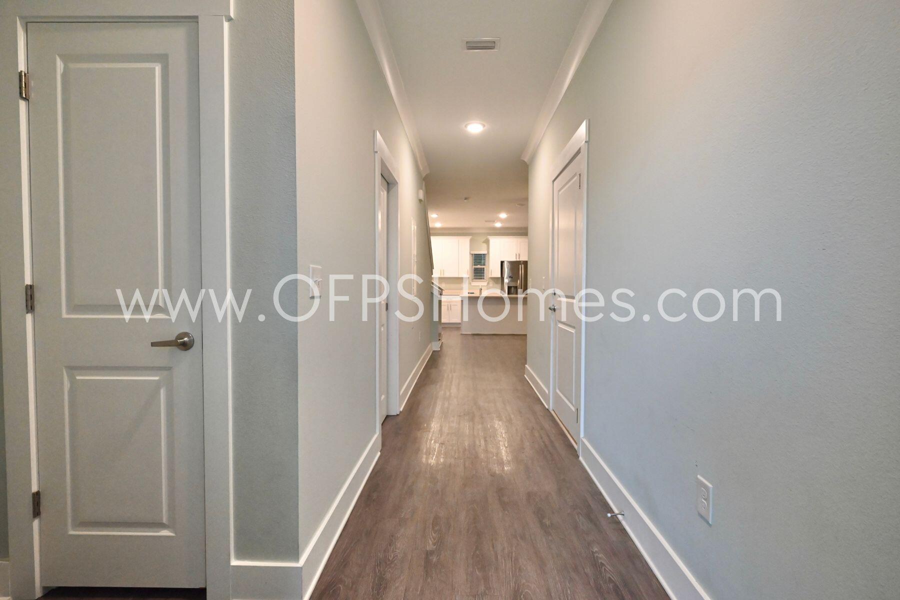 312 North Sand Palm Road Freeport, FL 32439 - Photo 5 of 26 a view of a hallway with wooden floor and staircase