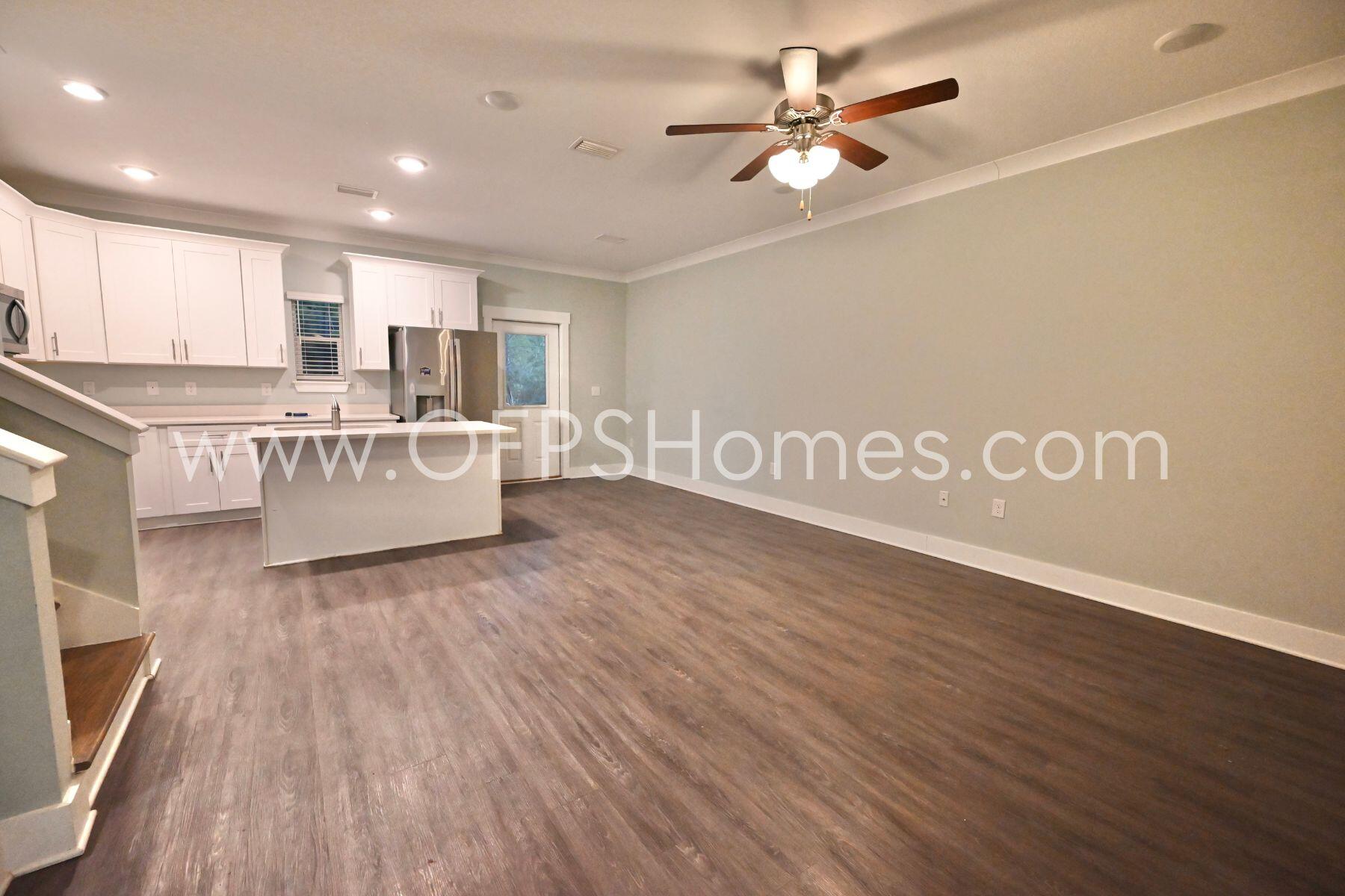 312 North Sand Palm Road Freeport, FL 32439 - Photo 6 of 26 a view of a kitchen with furniture a ceiling fan and wooden floor