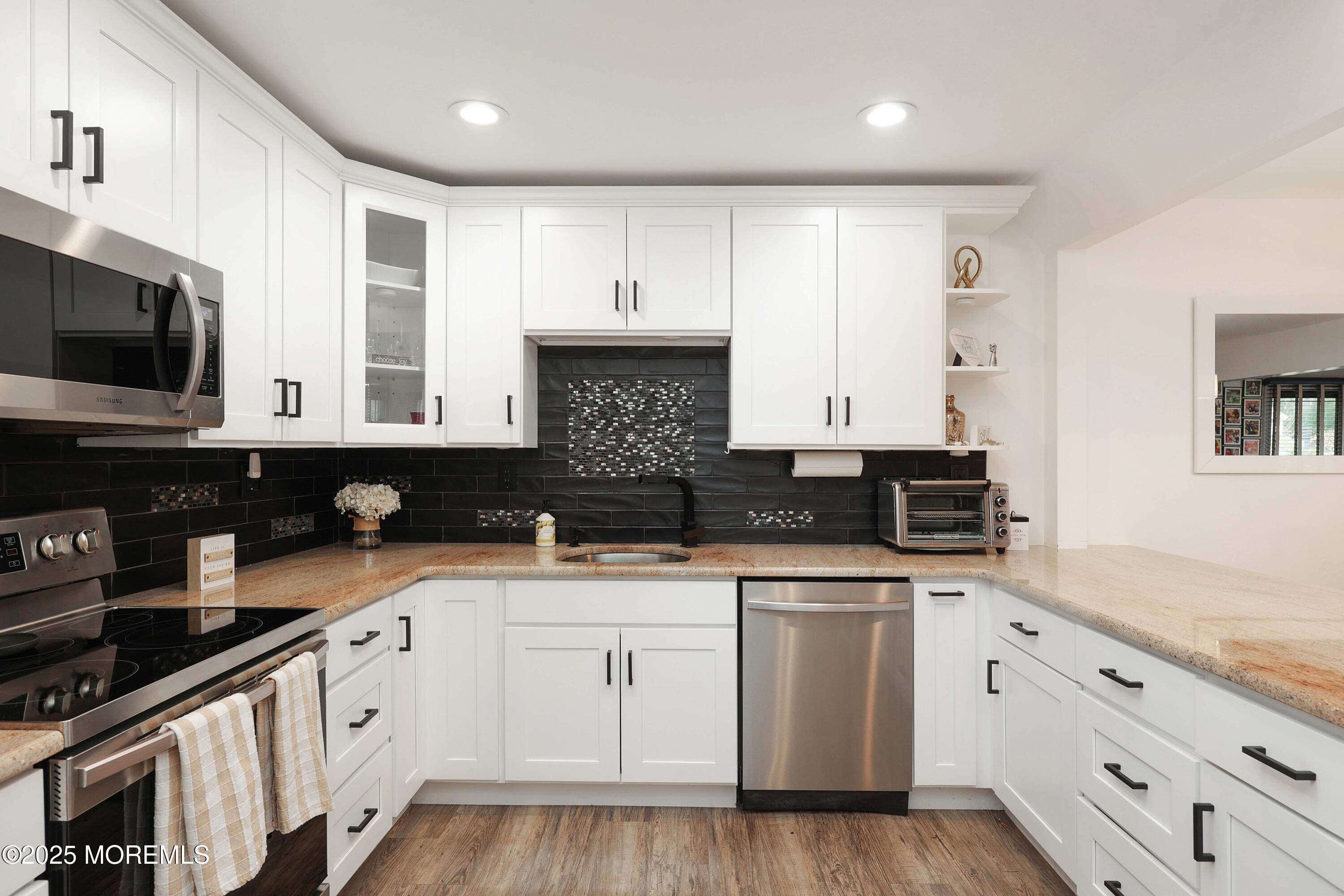 126 Manchester Court Red Bank, NJ 07701 - Photo 6 of 22 a kitchen with granite countertop white cabinets and stainless steel appliances