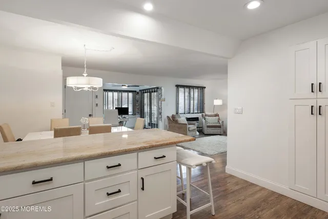 a kitchen with granite countertop white cabinets and stainless steel appliances