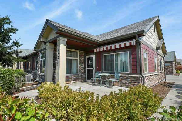a front view of a house with a garden and plants