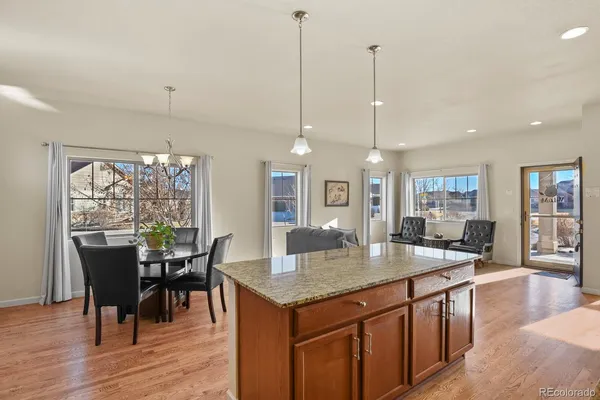 a view of a dining room and livingroom with furniture wooden floor a chandelier