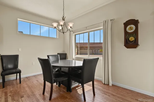 a view of a dining room with furniture a chandelier and wooden floor