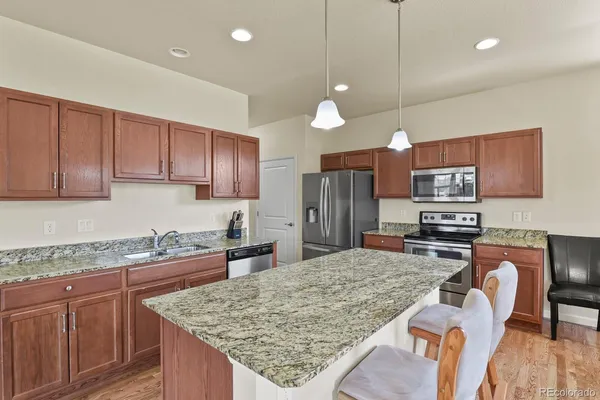 a kitchen with stainless steel appliances granite countertop a sink refrigerator and microwave