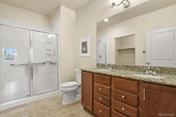 a bathroom with a granite countertop sink toilet and shower