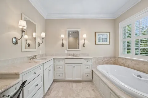 a spacious bathroom with a granite countertop sink mirror and a bathtub