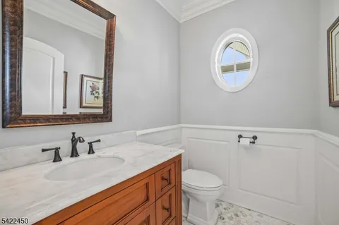 a bathroom with a granite countertop sink mirror and toilet