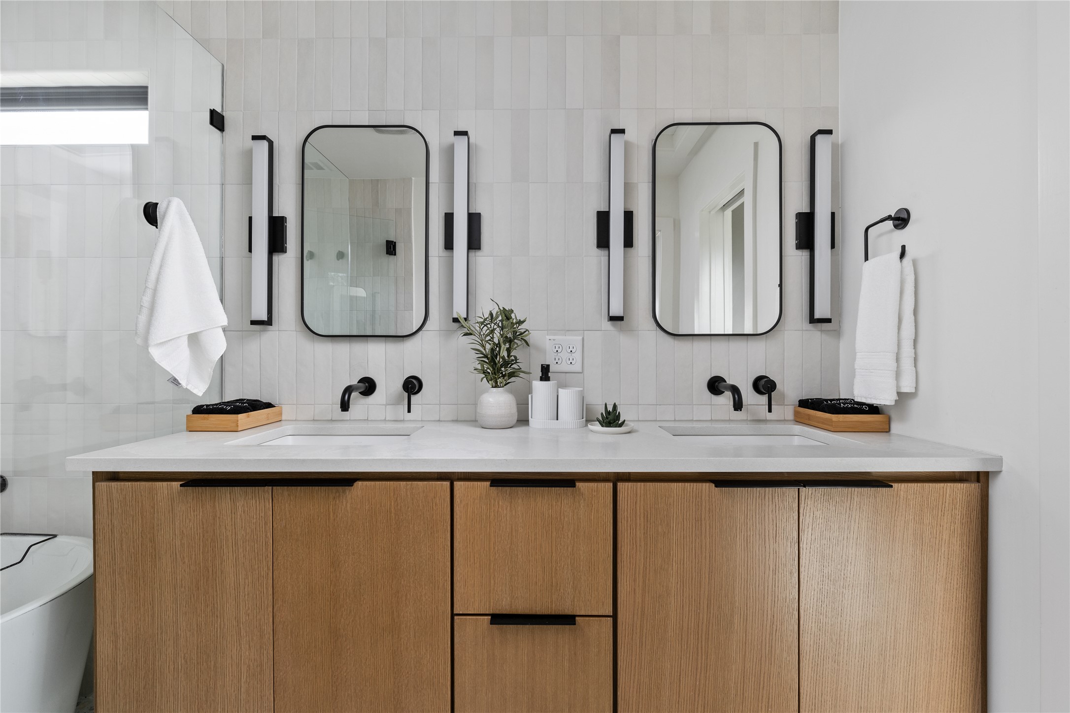 108 Comal Street Austin, TX 78702 - Photo 15 of 40 Bathroom with double vanity, a freestanding bath, tile walls, and tasteful backsplash