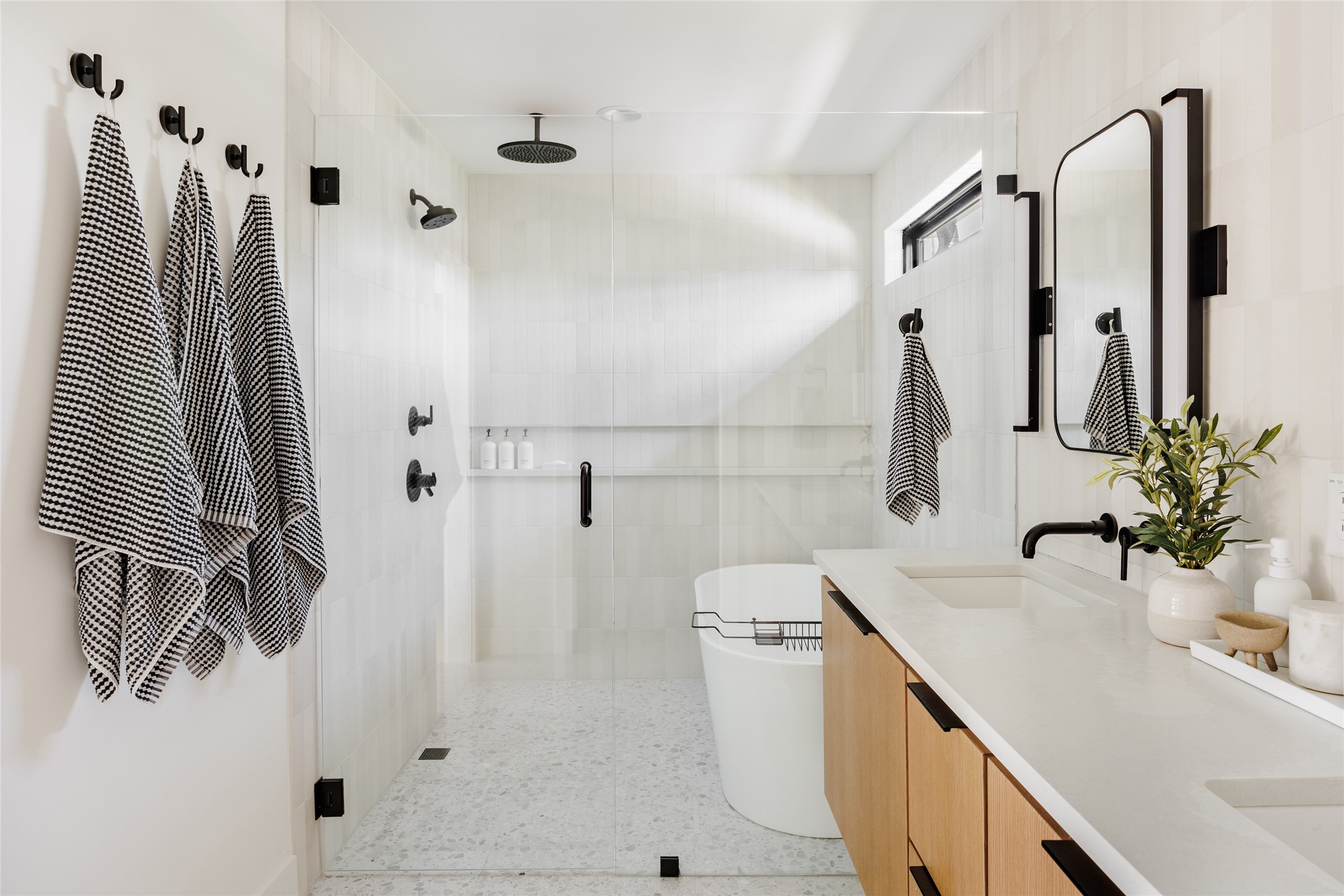108 Comal Street Austin, TX 78702 - Photo 16 of 40 Full bath with double vanity, a shower stall, a freestanding tub, tile walls, and dark speckled floor