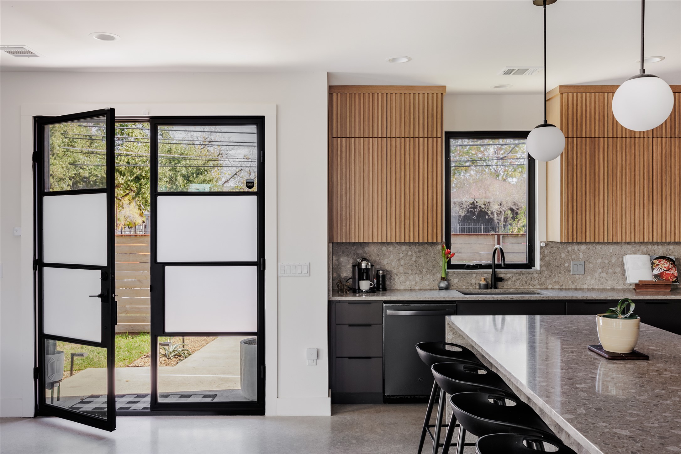 108 Comal Street Austin, TX 78702 - Photo 3 of 40 Kitchen featuring a breakfast bar area, stainless steel dishwasher, light stone countertops, and pendant lighting