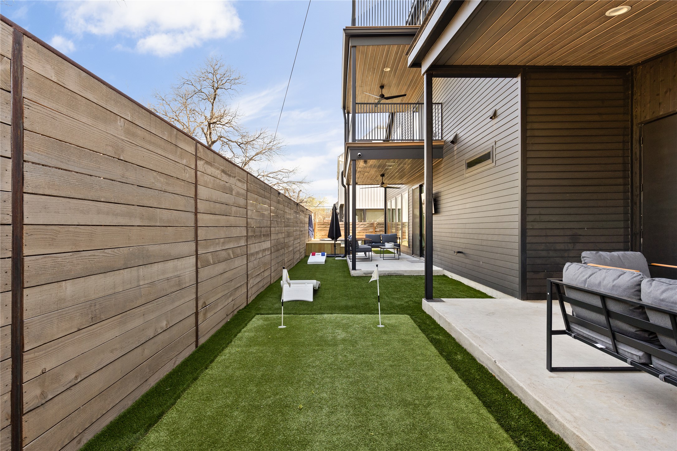 108 Comal Street Austin, TX 78702 - Photo 35 of 40 Fenced backyard featuring an area to practice putting, a patio, and an outdoor living space
