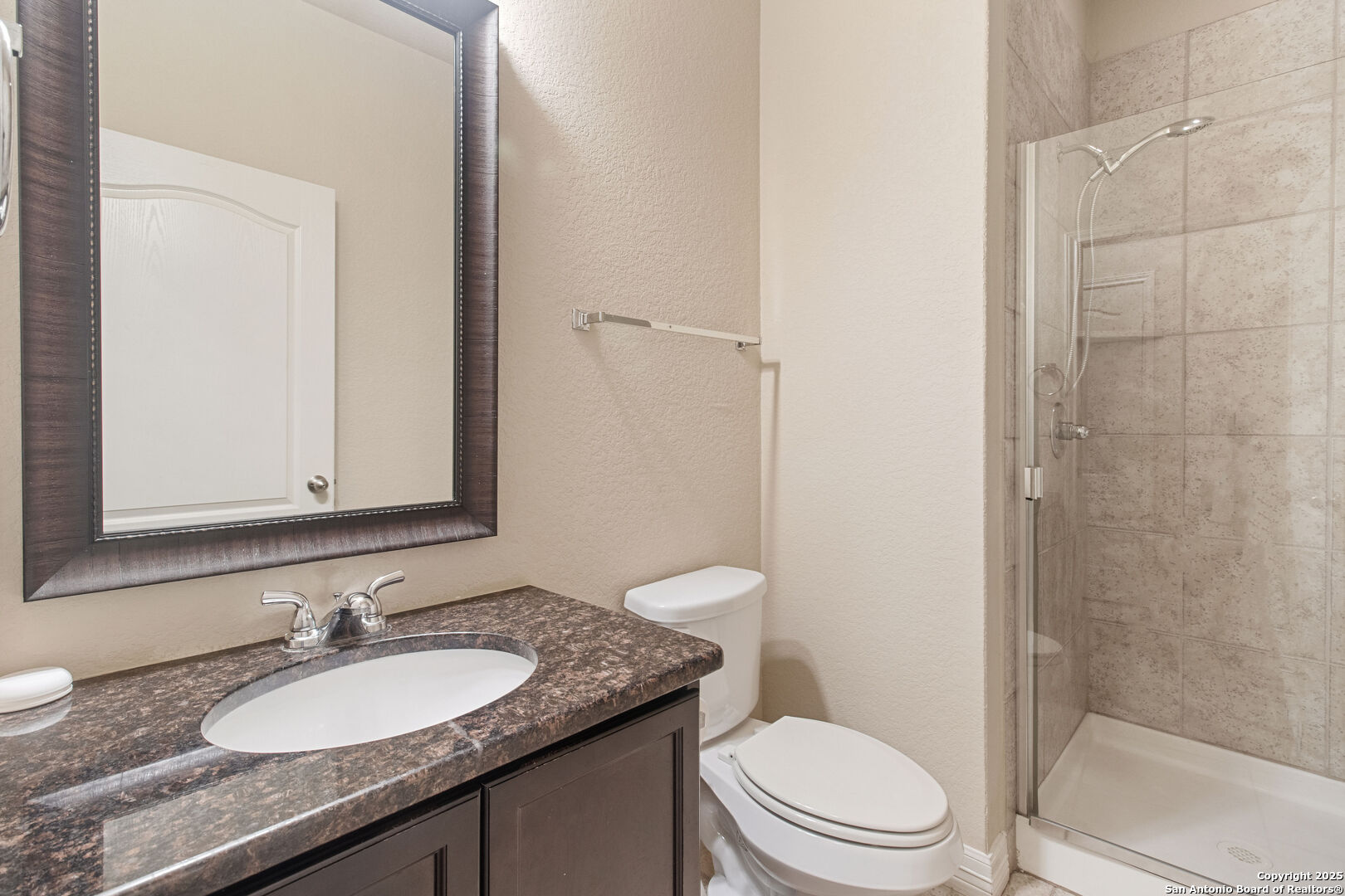 8806 Atwater Creek San Antonio, TX 78245 - Photo 7 of 16 a bathroom with a granite countertop sink toilet a mirror and shower