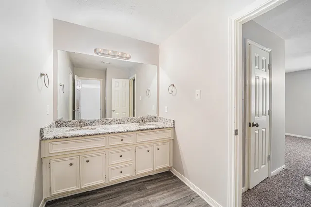 a en suite bathroom with a granite countertop sink and a mirror
