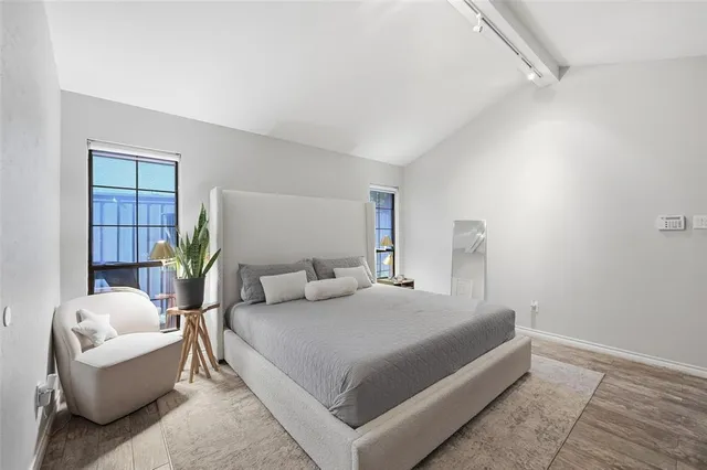 a bedroom with a bed couch and a potted plant