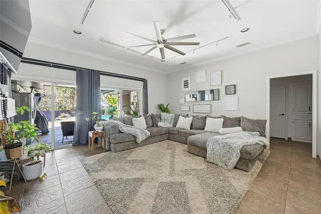 a bedroom with a bed a chandelier and couches