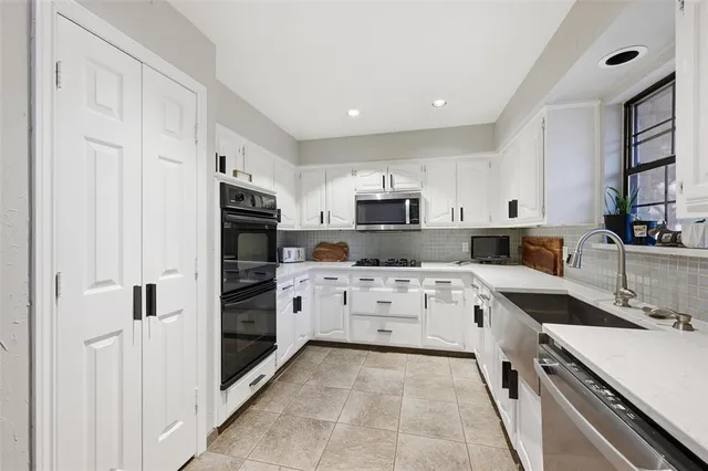 a kitchen with stainless steel appliances kitchen island granite countertop a refrigerator and a stove top oven