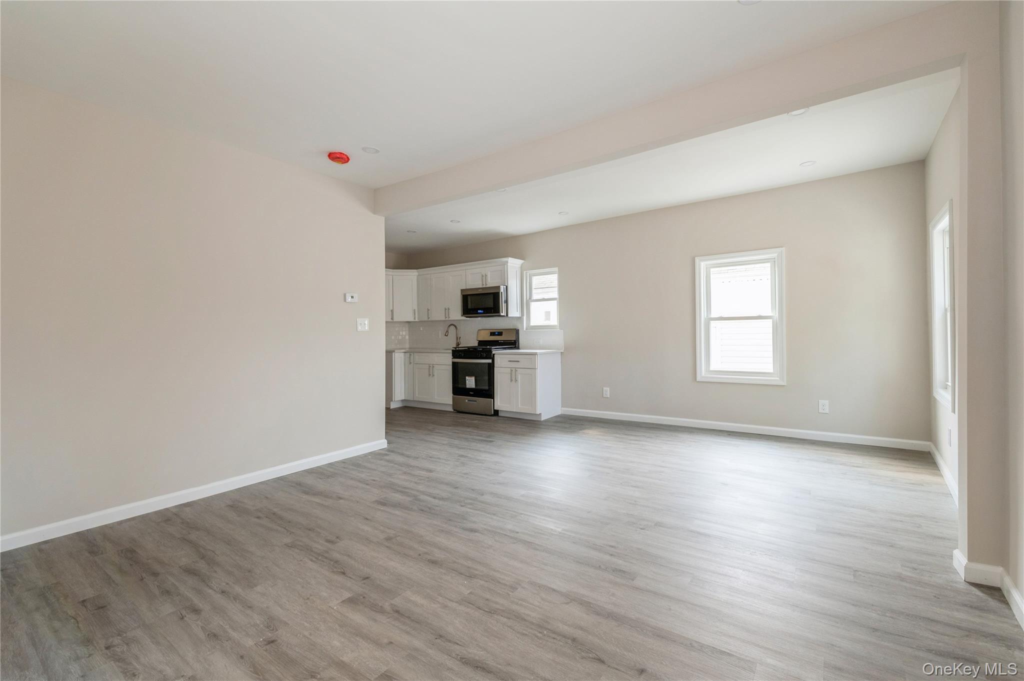 216-23 136th Road Queens, NY 11413 - Photo 11 of 28 Unfurnished living room with baseboards and light wood-type flooring