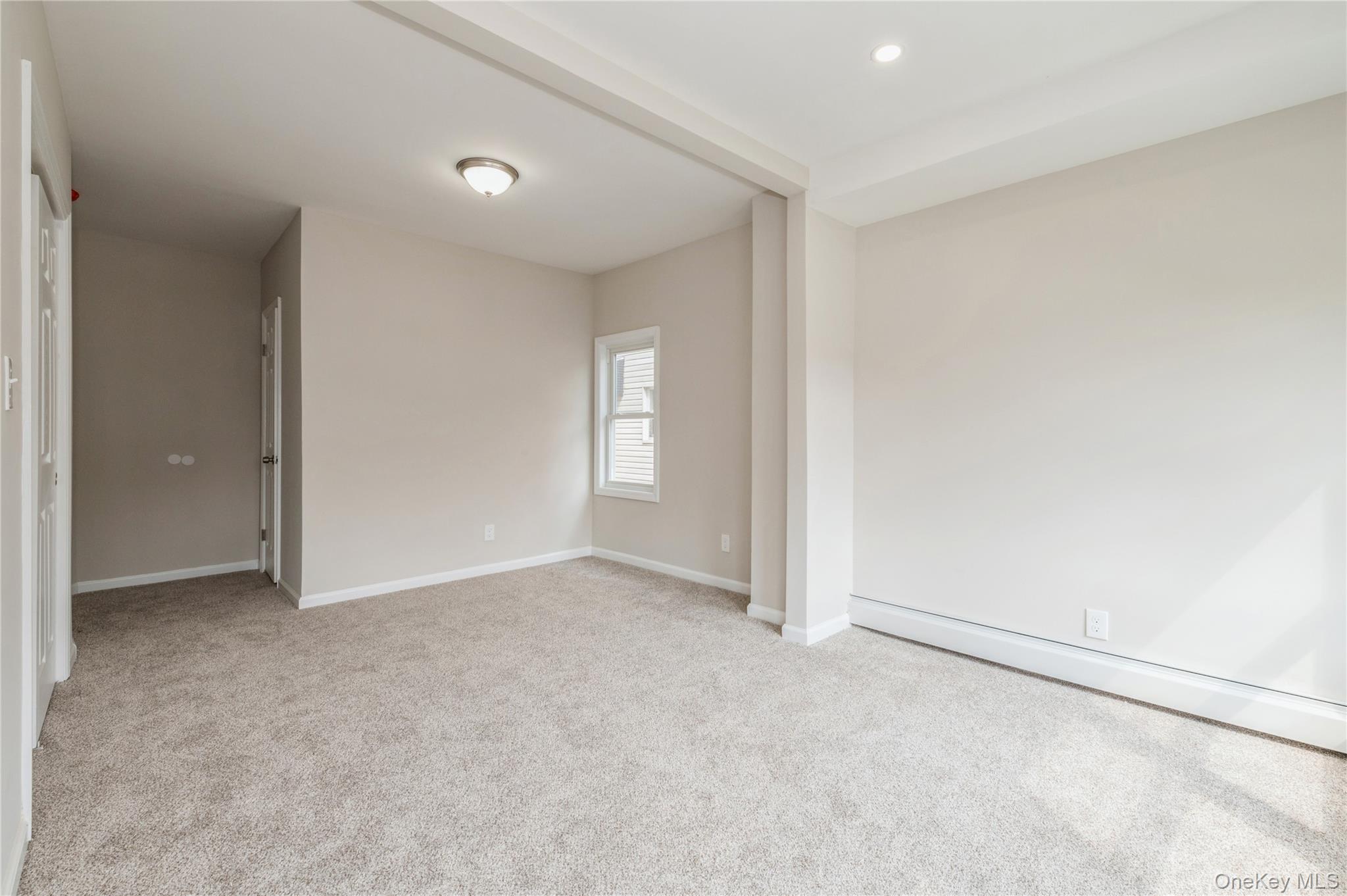 216-23 136th Road Queens, NY 11413 - Photo 6 of 28 Spare room featuring light colored carpet and a baseboard radiator
