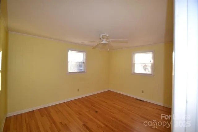 a view of a room with wooden floor and fan